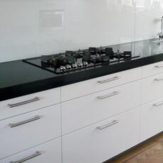 Een glazen keuken achterwand aan een wand gemonteerd